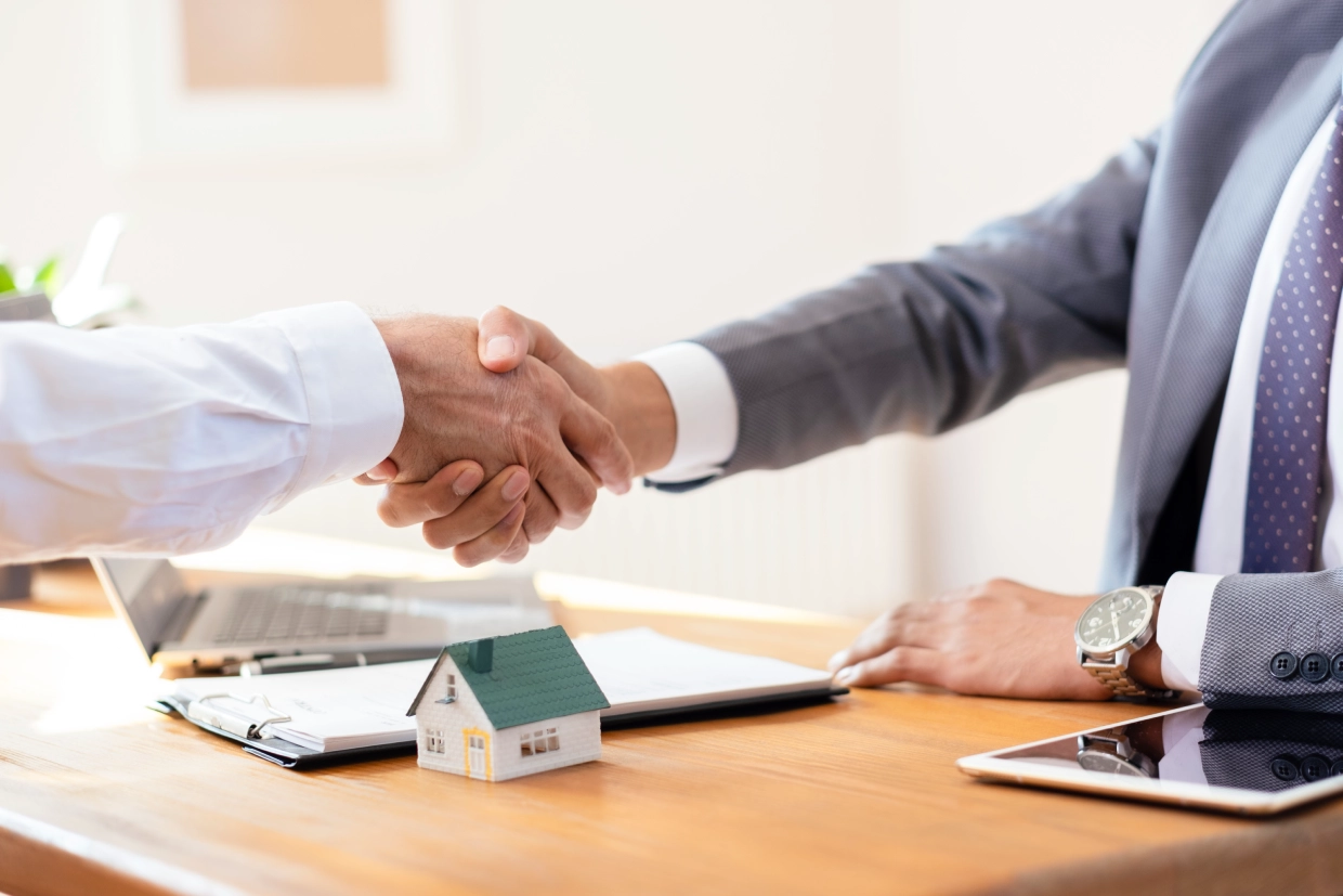 Real estate deal handshake at office desk